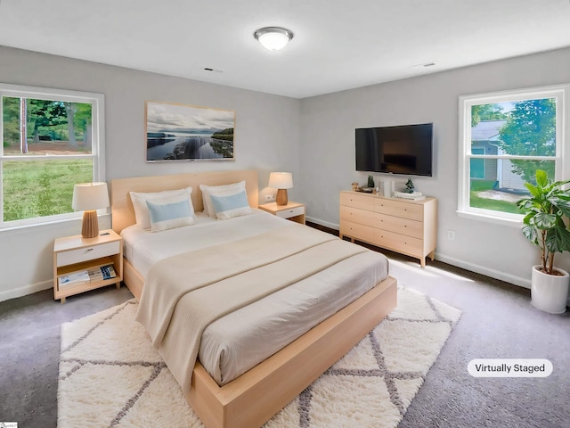 carpeted bedroom featuring visible vents, baseboards, and multiple windows