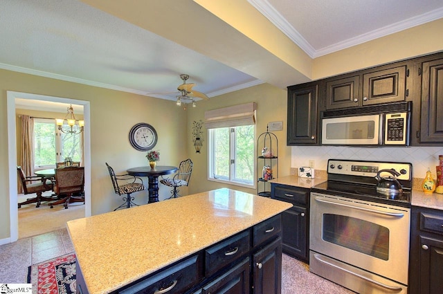 kitchen with backsplash, plenty of natural light, crown molding, and stainless steel appliances