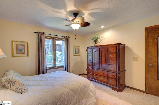 bedroom with light colored carpet, baseboards, and a textured ceiling