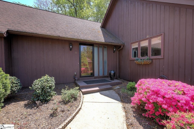 property entrance featuring a shingled roof