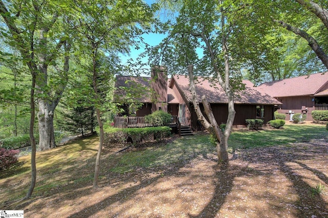 rear view of house featuring a chimney and a deck