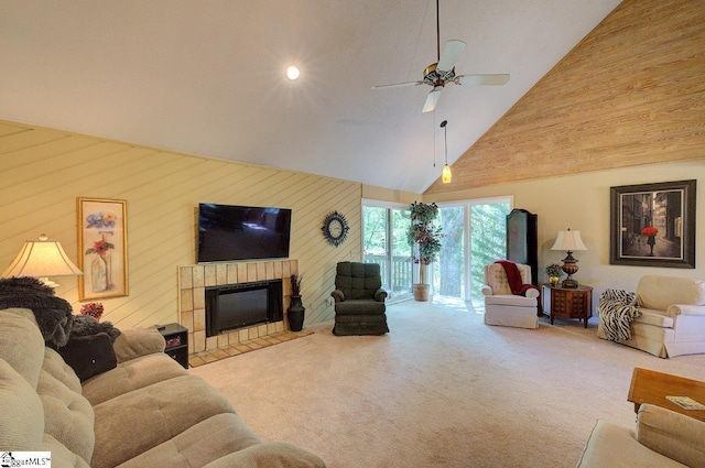 living room featuring carpet floors, a tile fireplace, high vaulted ceiling, and ceiling fan