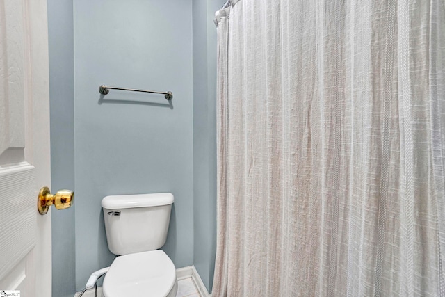 bathroom with toilet and baseboards