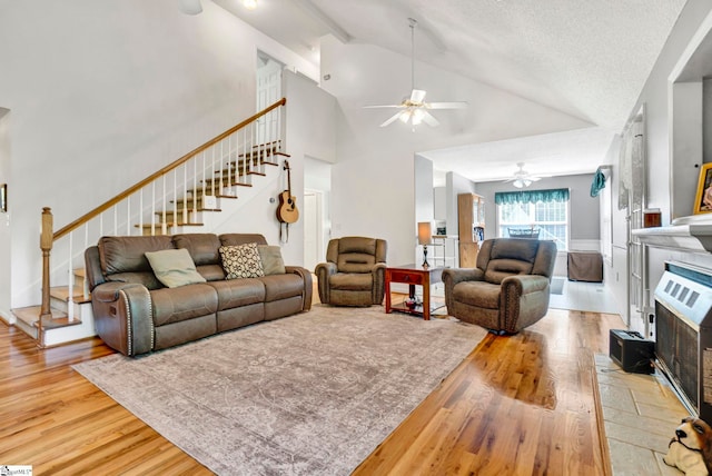 living room with high vaulted ceiling, wood finished floors, stairs, and ceiling fan