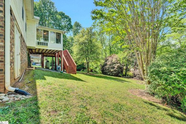 view of yard featuring a sunroom and stairway