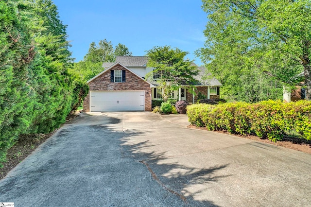 traditional-style home with a garage, brick siding, and concrete driveway
