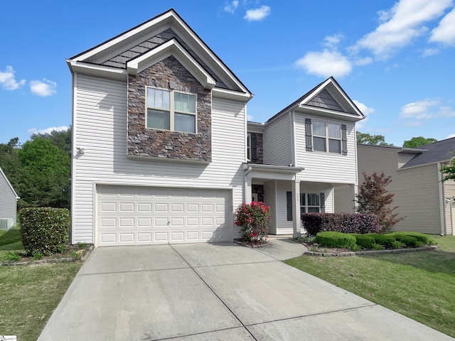 view of front of property featuring stone siding, driveway, a front yard, and a garage
