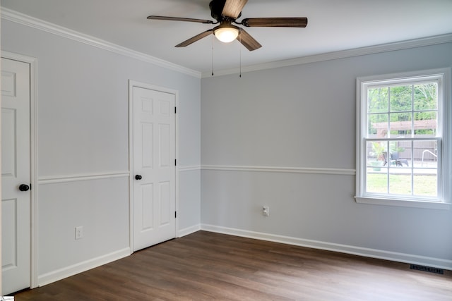 unfurnished room with a ceiling fan, a healthy amount of sunlight, dark wood-type flooring, and visible vents