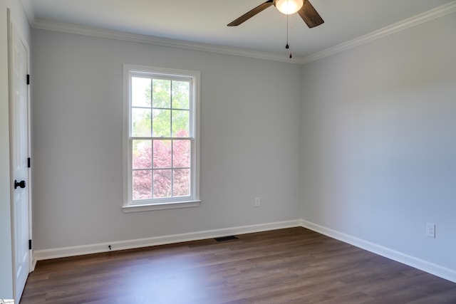 empty room with baseboards, visible vents, crown molding, and dark wood-style floors