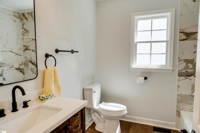 full bath with toilet, baseboards, visible vents, wood finished floors, and vanity