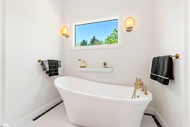 full bathroom with baseboards, tile patterned flooring, and a freestanding bath