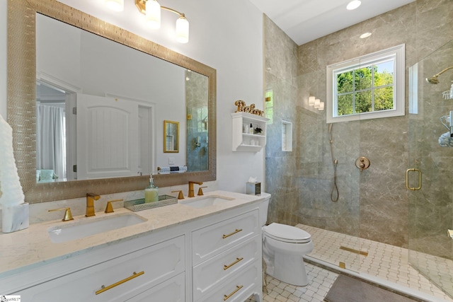 full bathroom with a sink, a shower stall, double vanity, and toilet