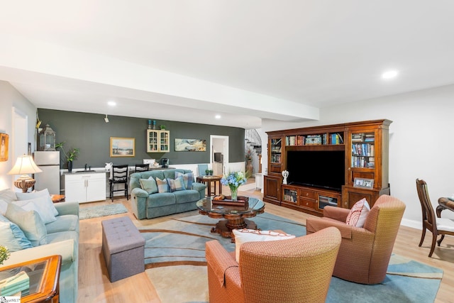 living room featuring light wood finished floors, baseboards, and recessed lighting