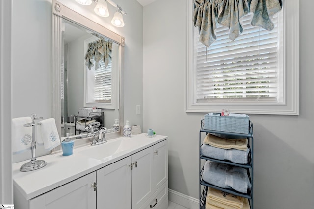 bathroom featuring baseboards, a wealth of natural light, and vanity