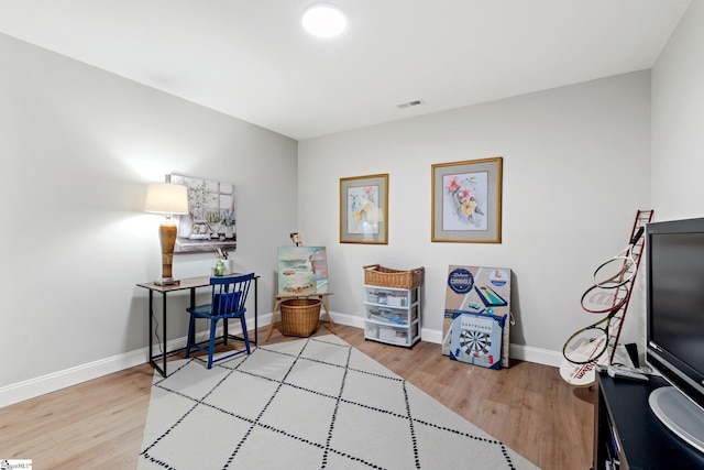 sitting room featuring light wood finished floors, baseboards, and visible vents