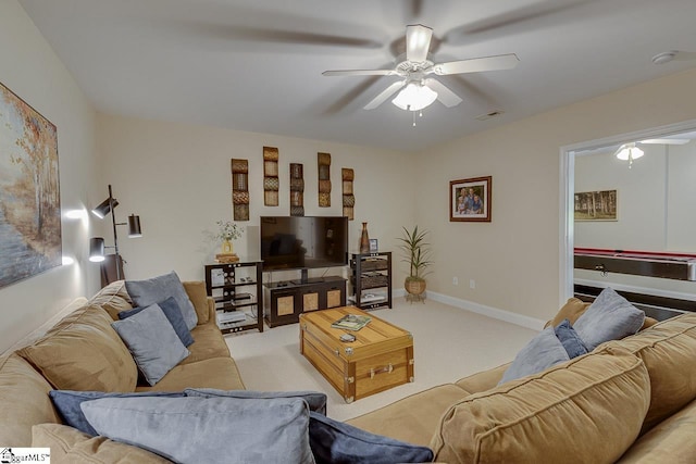 living room featuring baseboards, visible vents, light colored carpet, and ceiling fan