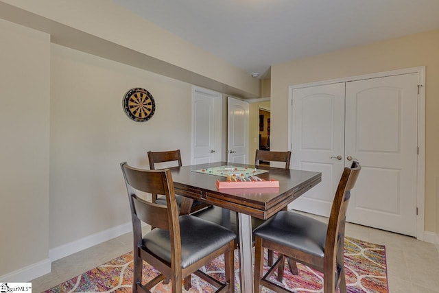dining space with baseboards and light tile patterned floors