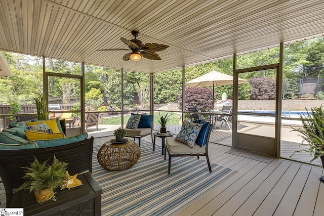 sunroom featuring a ceiling fan and outdoor lounge area