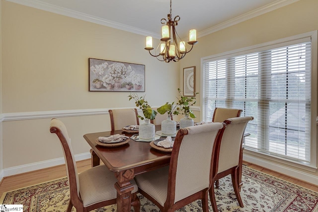 dining room with baseboards, wood finished floors, an inviting chandelier, and ornamental molding