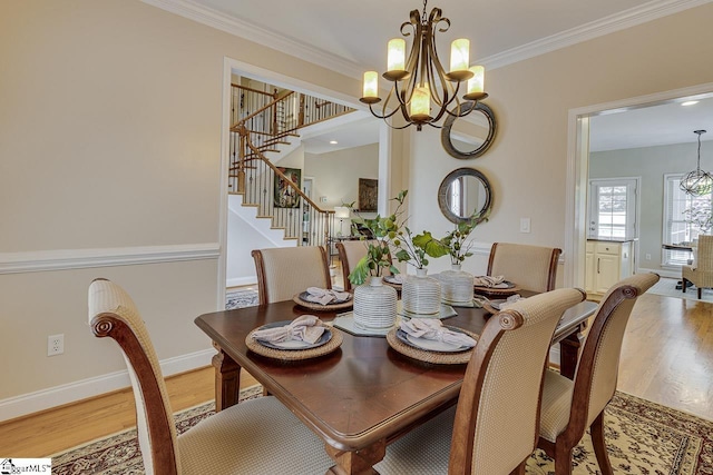 dining room with stairway, ornamental molding, a chandelier, and light wood finished floors