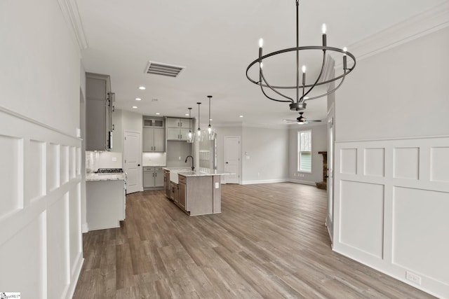 kitchen with crown molding, open floor plan, and gray cabinets