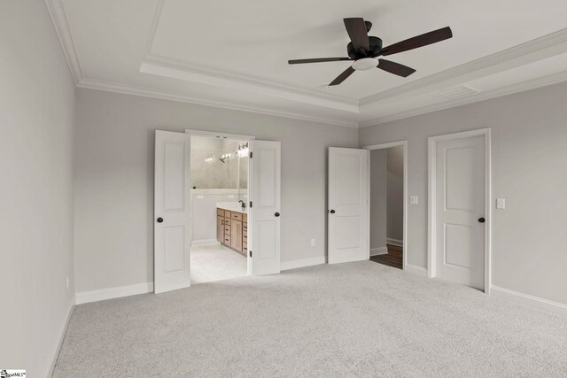 unfurnished bedroom with light carpet, ornamental molding, a tray ceiling, and visible vents