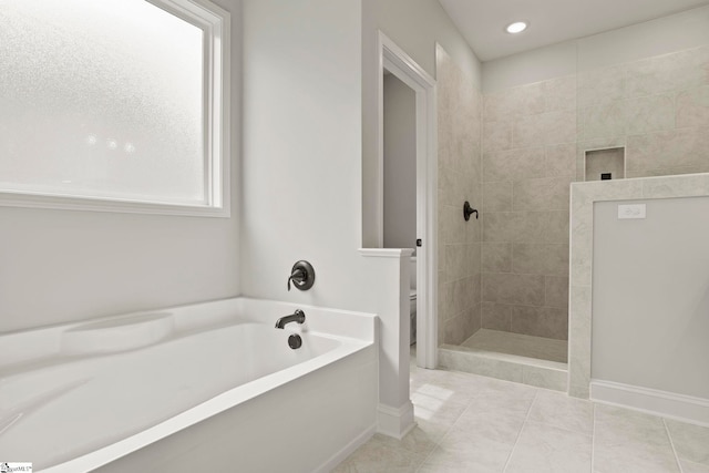bathroom with toilet, walk in shower, a garden tub, and baseboards
