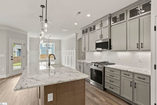 kitchen featuring ornamental molding, backsplash, appliances with stainless steel finishes, and a sink