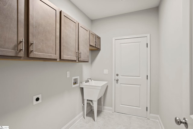 washroom featuring baseboards, washer hookup, hookup for an electric dryer, and cabinet space
