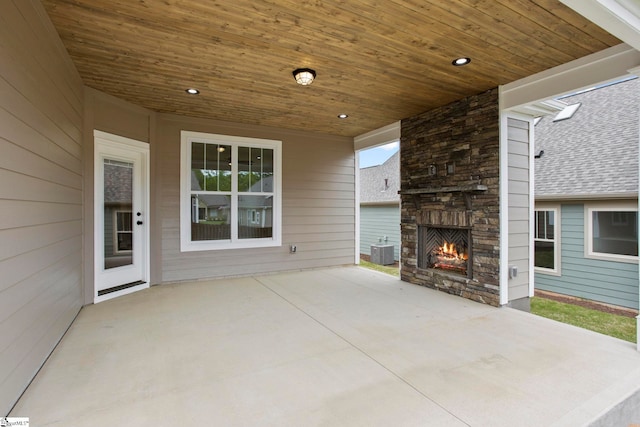 view of patio / terrace with an outdoor stone fireplace and central AC