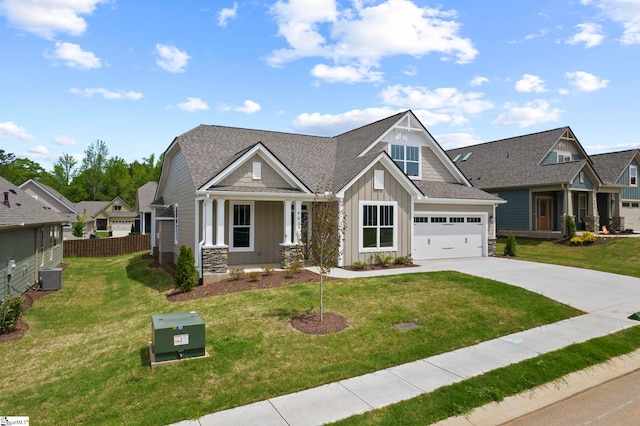 craftsman-style home featuring concrete driveway, board and batten siding, fence, a front yard, and roof with shingles