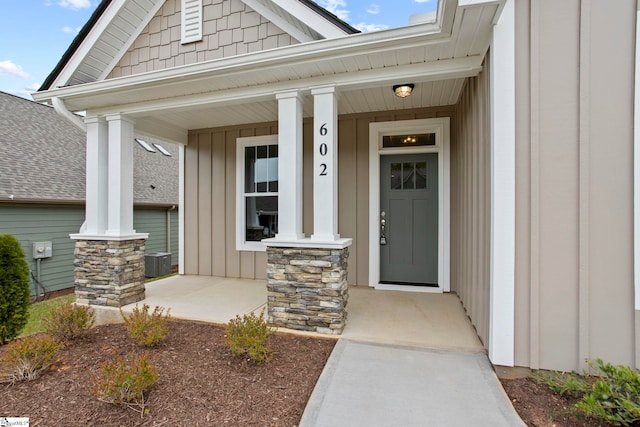 doorway to property featuring central air condition unit, board and batten siding, and covered porch