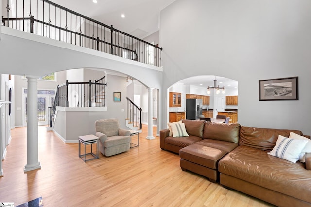 361 E Killarney Lk, Moore, SC 29369 - living room with light wood finished floors, arched walkways, a towering ceiling, a notable chandelier, and stairs