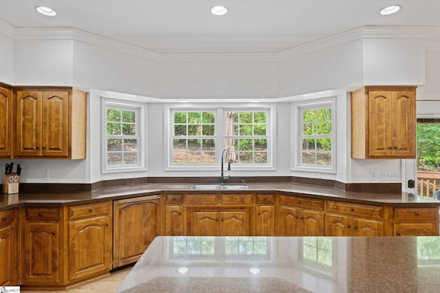 361 E Killarney Lk, Moore, SC 29369 - kitchen featuring dark stone counters, paneled dishwasher, a sink, brown cabinets, and ornamental molding