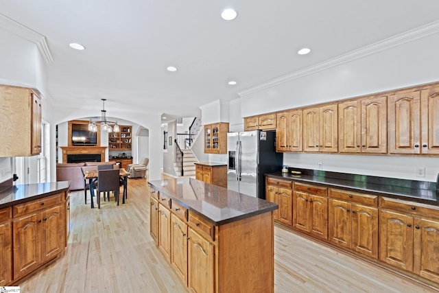 361 E Killarney Lk, Moore, SC 29369 - kitchen featuring light wood-style flooring, stainless steel refrigerator with ice dispenser, a fireplace, a kitchen island, and ornamental molding