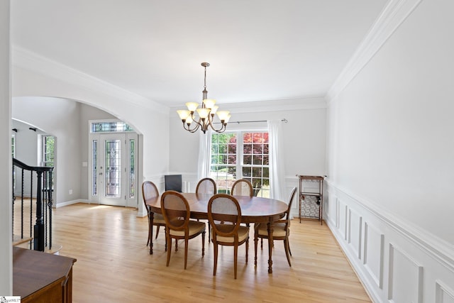361 E Killarney Lk, Moore, SC 29369 - dining area featuring arched walkways, light wood-style floors, a notable chandelier, a decorative wall, and ornamental molding