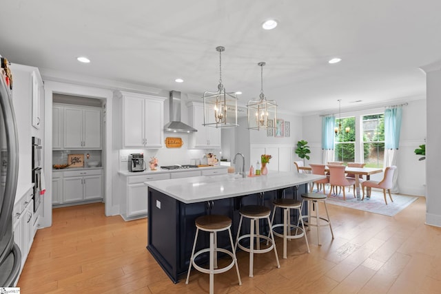309 Nebbiolo Ln, Simpsonville, SC 29681 - kitchen featuring wall chimney exhaust hood, appliances with stainless steel finishes, a kitchen bar, white cabinets, and light countertops