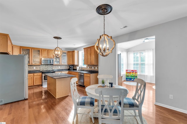 kitchen with visible vents, a center island, decorative backsplash, a chandelier, and appliances with stainless steel finishes