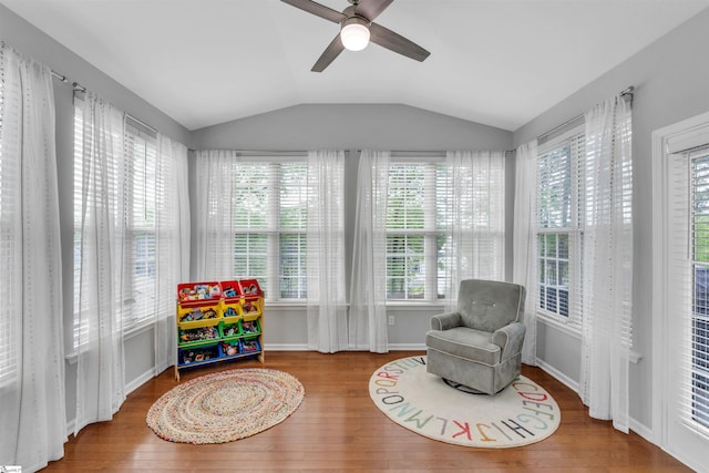 living area with ceiling fan, lofted ceiling, wood finished floors, and baseboards