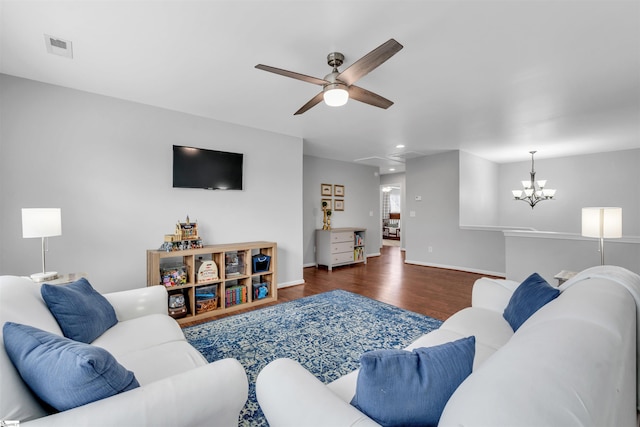 living area with baseboards, wood finished floors, visible vents, and ceiling fan with notable chandelier