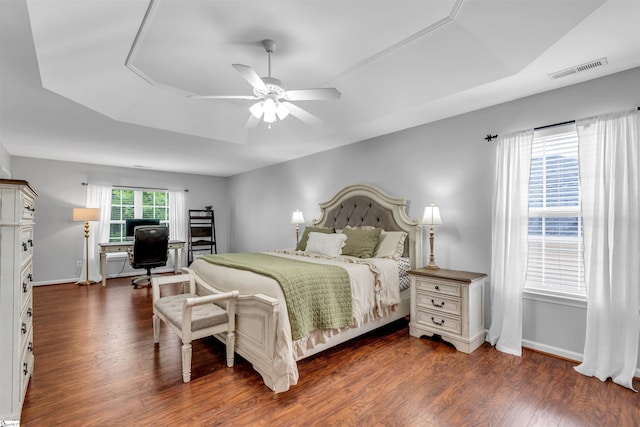 bedroom featuring ceiling fan, baseboards, wood finished floors, and visible vents