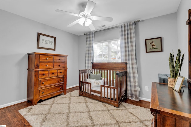 bedroom featuring baseboards, a ceiling fan, wood finished floors, and visible vents