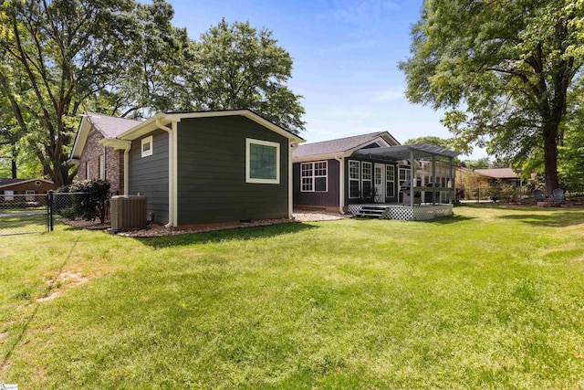 back of house with fence, a lawn, a wooden deck, and central AC unit