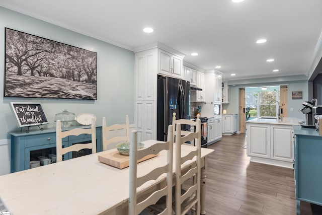 dining space featuring dark wood-style flooring, ornamental molding, and recessed lighting