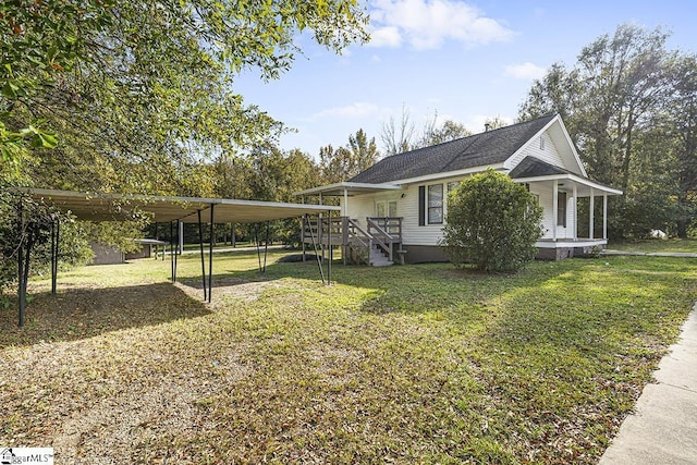 view of front of house with a detached carport, a shingled roof, and a front yard