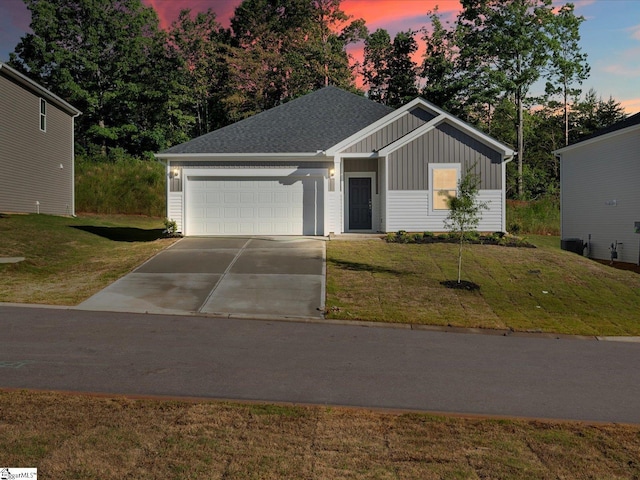 225 Maxwell Dr, Easley, SC 29642 - view of front of house featuring board and batten siding, a garage, driveway, a yard, and a shingled roof