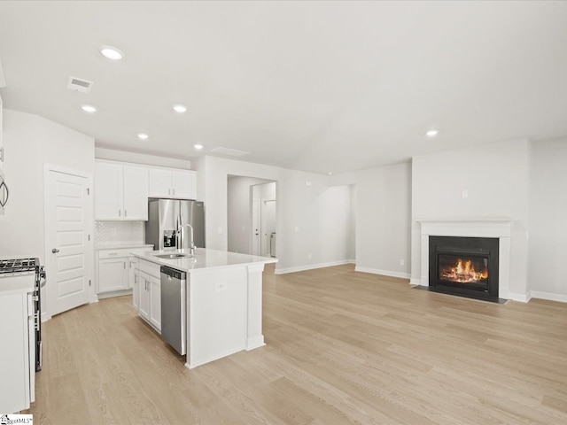 225 Maxwell Dr, Easley, SC 29642 - kitchen featuring stainless steel appliances, light wood finished floors, light countertops, a center island with sink, and recessed lighting