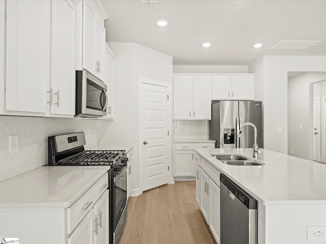 225 Maxwell Dr, Easley, SC 29642 - kitchen featuring appliances with stainless steel finishes, a sink, light wood-style flooring, tasteful backsplash, and a center island with sink