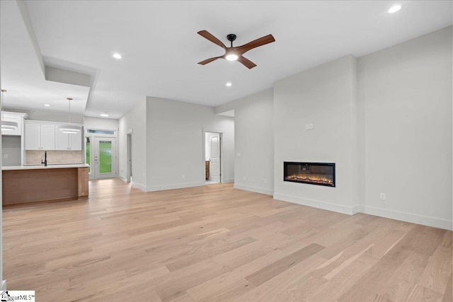 204 Tot Howell Rd, Greer, SC 29651 - unfurnished living room with recessed lighting, a ceiling fan, a glass covered fireplace, and light wood-type flooring