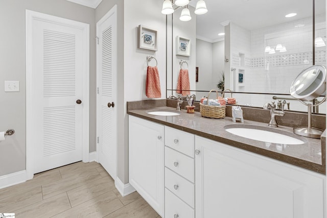 full bath with baseboards, a sink, and ornamental molding